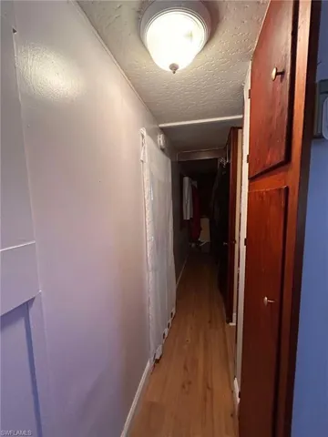 Hallway with light hardwood / wood-style flooring