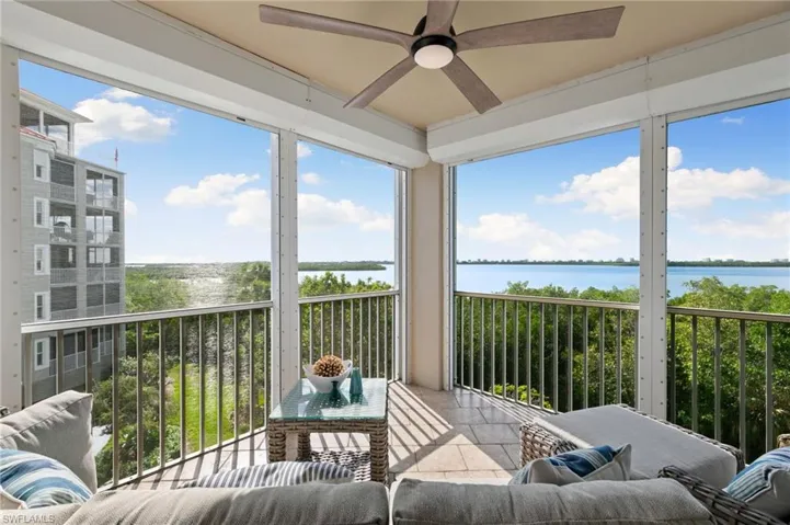Sunroom / solarium featuring ceiling fan and a water view