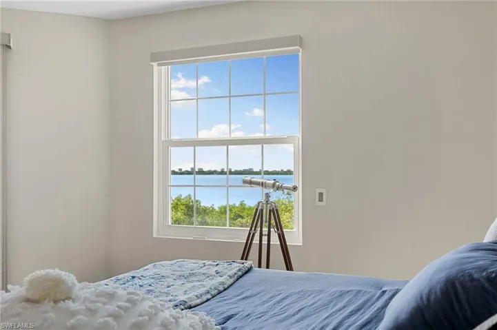 Bedroom featuring a water view and multiple windows