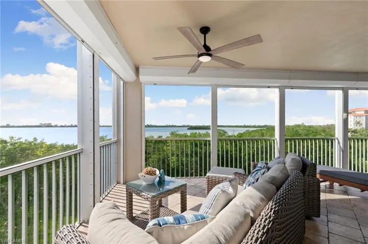 Sunroom / solarium featuring a water view, plenty of natural light, and ceiling fan
