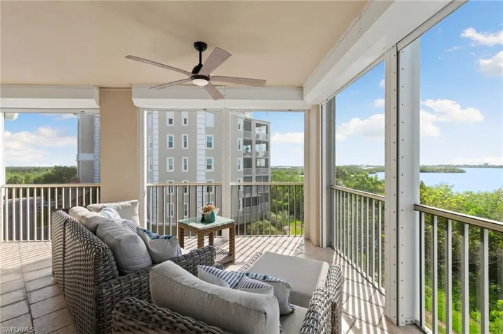 Sunroom featuring ceiling fan and a water view