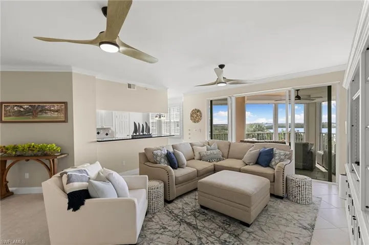 Tiled living room featuring ceiling fan and crown molding