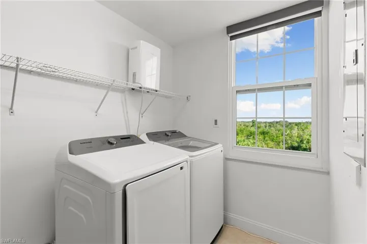 Washroom with washing machine and clothes dryer and a wealth of natural light