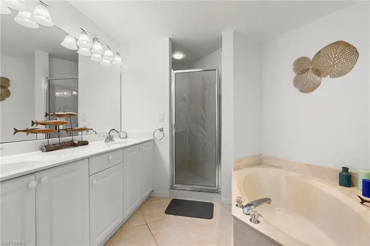 Bathroom featuring vanity, independent shower and bath, and tile patterned flooring