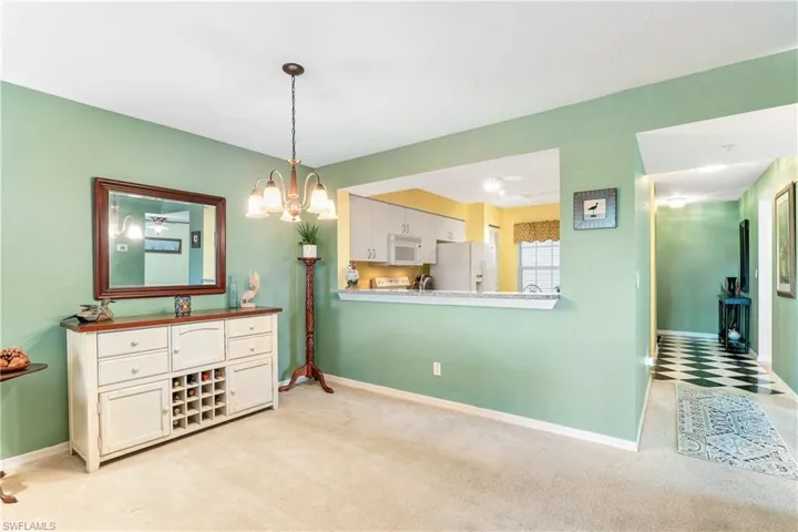 Carpeted dining space with a notable chandelier