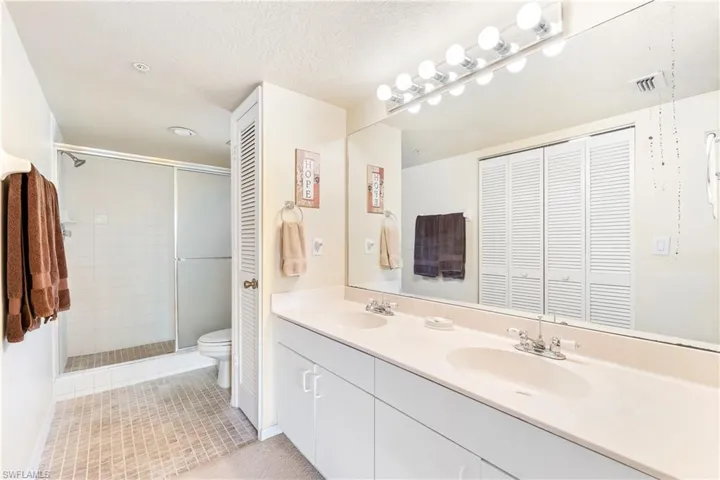Primate suite bathoromm with dual sinks textured ceiling, vanity,
