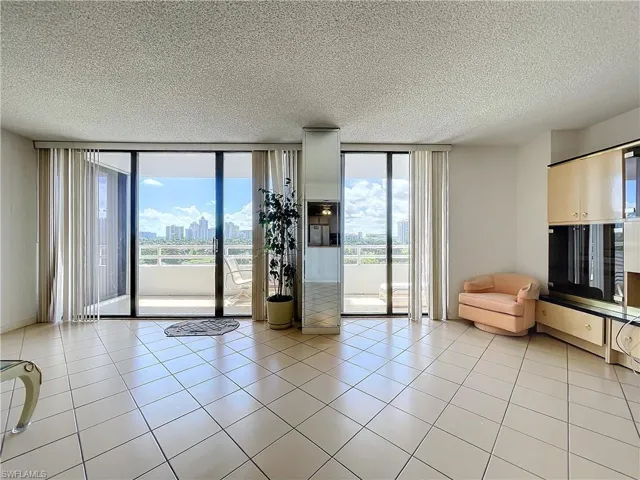 Unfurnished room featuring a textured ceiling, floor to ceiling windows, and plenty of natural light