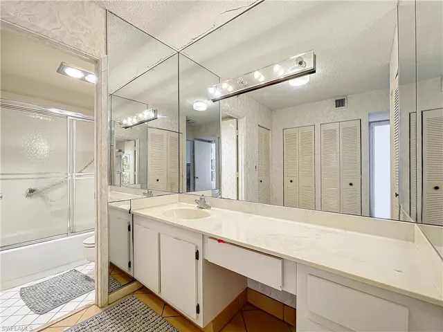 Bathroom featuring a closet, tile patterned flooring, and vanity