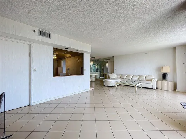 Living room featuring visible vents and a textured ceiling