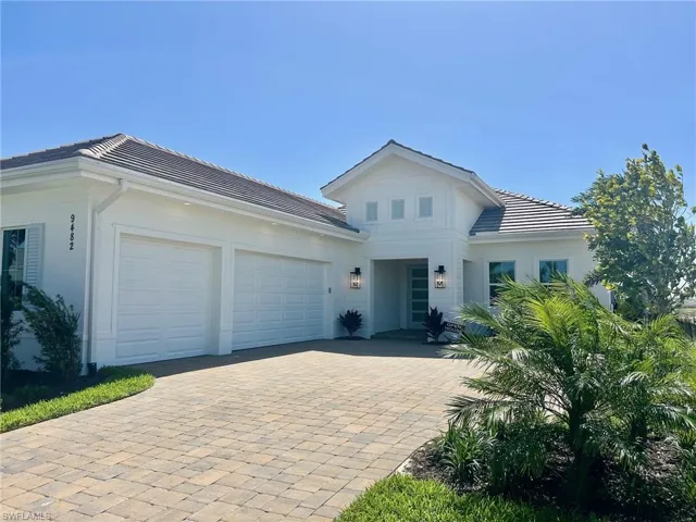 View of front of property featuring a garage, decorative driveway, a tiled roof, and stucco siding