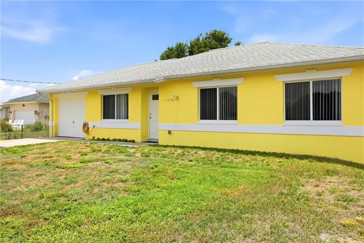 Single-story residence featuring a vibrant yellow exterior with white trim, a white entry door, and a white garage door