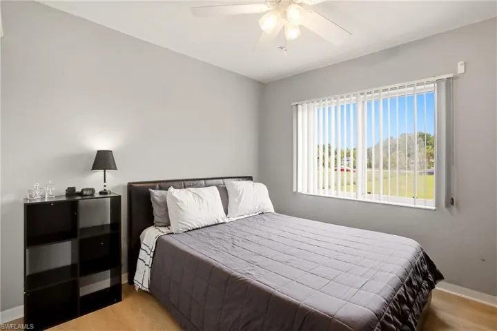 Bedroom with light gray walls and wood-finish flooring