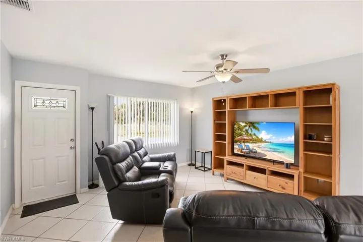 Living space featuring light-colored walls and a ceiling fan