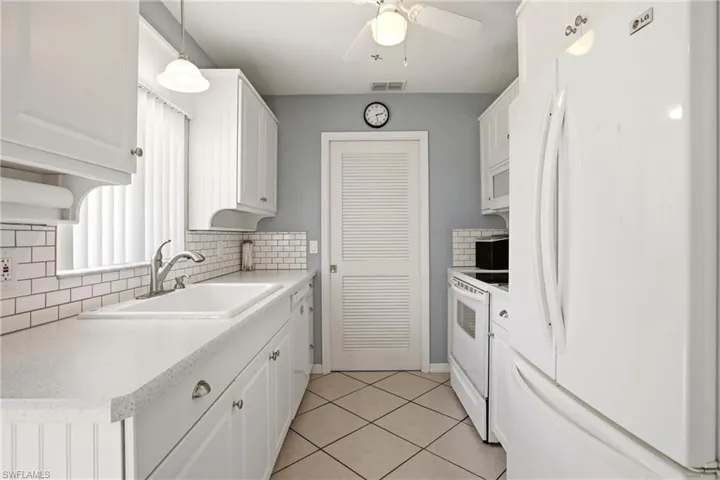 Kitchen featuring white cabinetry, light-toned countertops, a white subway tile backsplash, and diagonal tile flooring