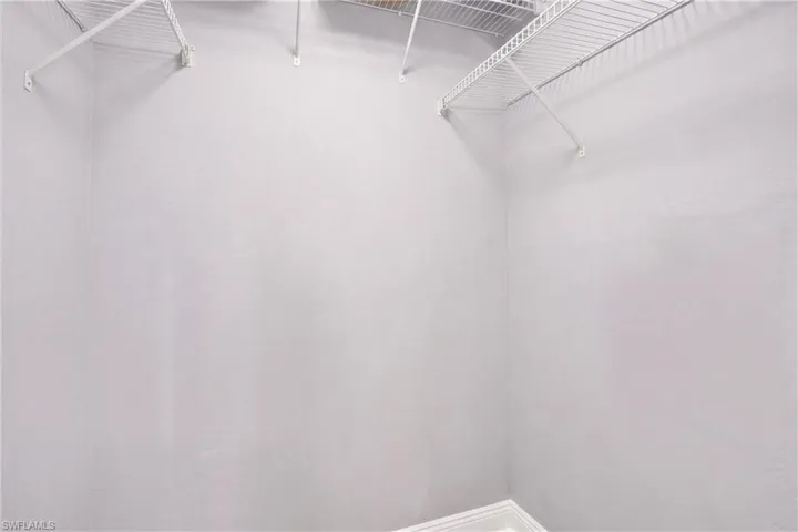 Walk-in closet featuring light walls, white wire shelving, and white baseboard trim
