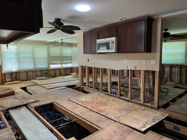 Kitchen with ceiling fan, dark brown cabinetry, and hardwood / wood-style floors