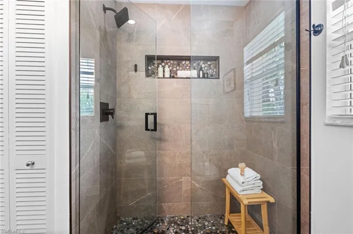 Secondary bathroom featuring an upgraded walk in shower and shower niche
