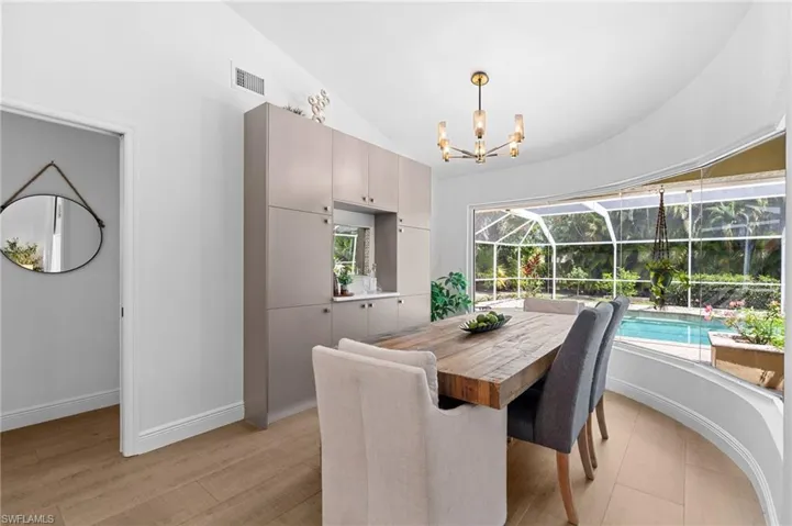 Dining room with custom built bar area and plenty of storage with stunning pool view