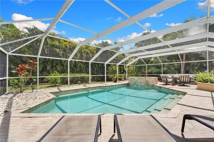 Heated pool and spa with a lush landscaped view