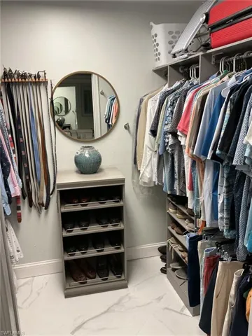 Walk in closet with light marble finish floors