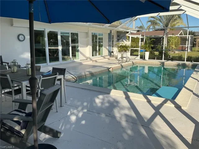 Swimming pool featuring a patio area, a sunroom, and a lanai