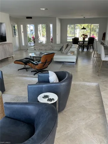 Living area featuring healthy amount of natural light, french doors, and light tile patterned flooring