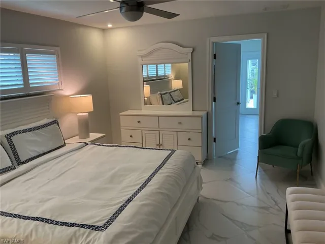 Bedroom with light marble finish floors, ceiling fan, and recessed lighting