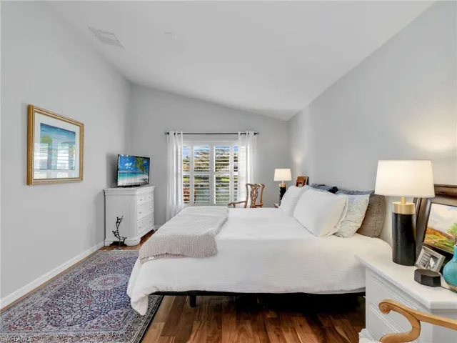 Bedroom featuring vaulted ceiling and wood finished floors