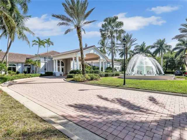 View of front of house with a front yard, stucco siding, decorative driveway, and a tiled roof