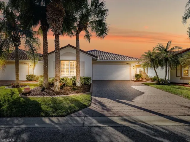Mediterranean / spanish-style house featuring decorative driveway, an attached garage, stucco siding, and a tiled roof