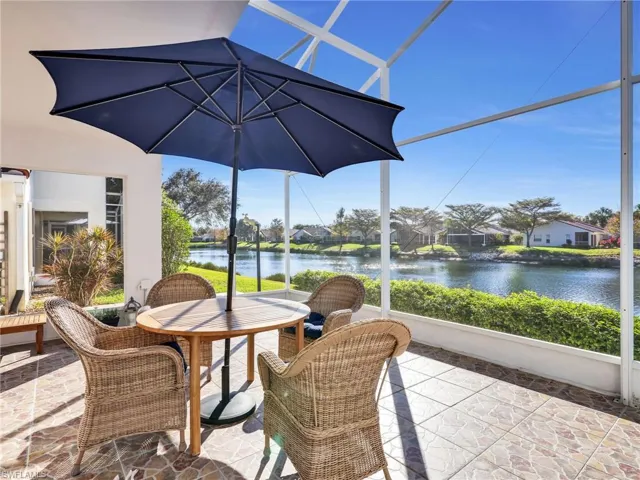 Sunroom featuring a residential view, stone tile floors, and a water view