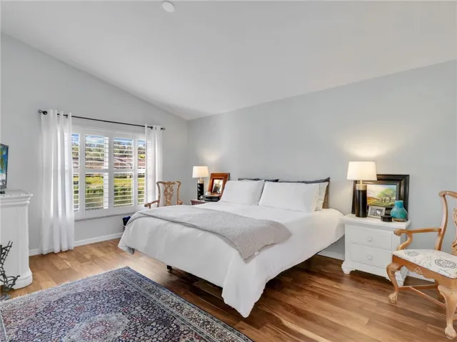 Bedroom with light wood-style flooring and vaulted ceiling