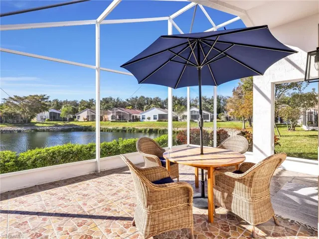 Sunroom / solarium with a residential view, outdoor dining space, lofted ceiling, a water view, and a patio
