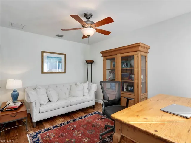 Office with wood finished floors and a ceiling fan