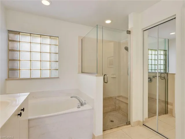 Bathroom with a shower stall, a bath, vanity, recessed lighting, and light tile patterned floors