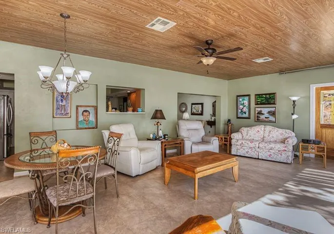 Living room featuring wood ceiling, hanging lights, and a ceiling fan