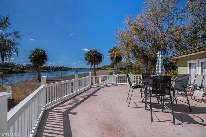 Concrete patio featuring view of Caloosahatchee River  and outdoor dining area