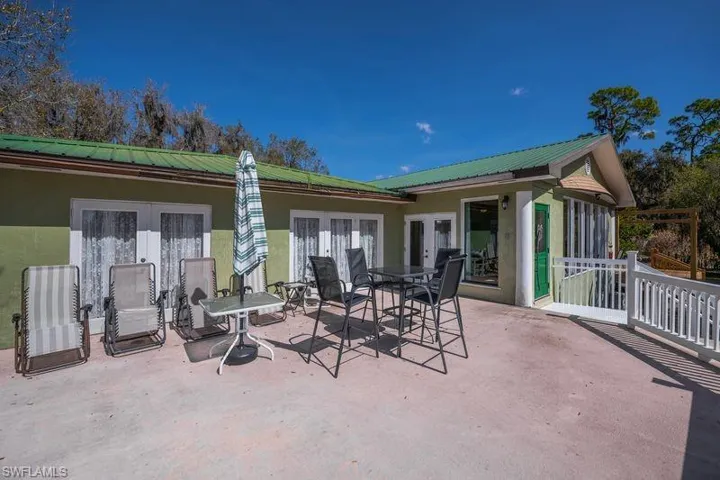 View of concrete patio  with french doors and outdoor dining area