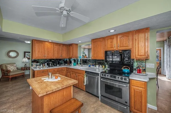 Kitchen featuring tasteful backsplash, wood finish cabinetry, Corian countertops, and stainless steel appliances
