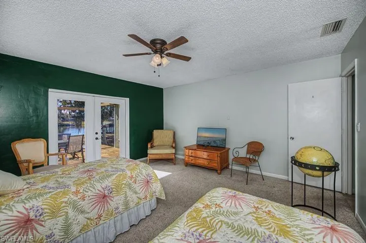 Bedroom 3 featuring french doors, carpet, a textured ceiling, ceiling fan, and access to exterior