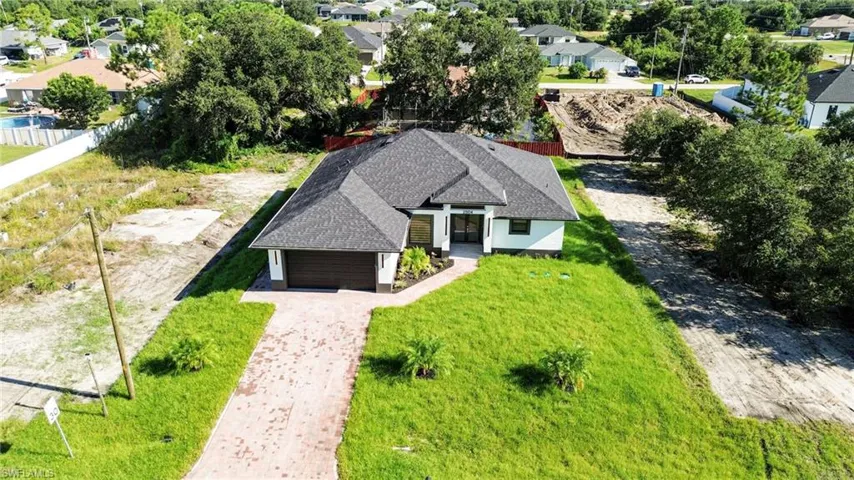 Modern exterior with a dark-pitched roof, attached garage, and a paver driveway