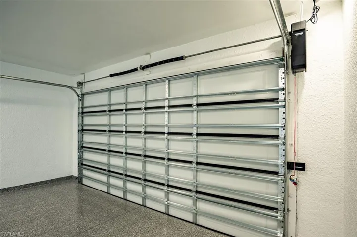 Garage with automated overhead door system and speckled flooring