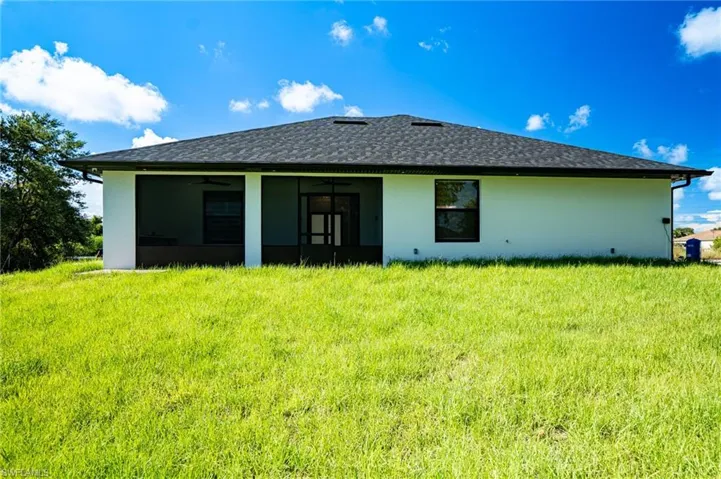 Modern single-story residence featuring a clean-lined architectural design with light-colored exterior walls and a dark hip roof