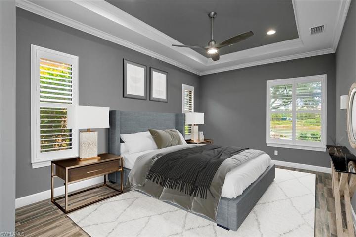 Owner suite is large and spacious and features a beautiful tray ceiling with crown molding and plantation shutters. (photo digitally staged)
