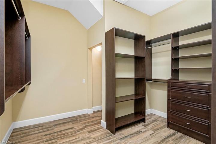 This huge owner closet has custom built-in shelving and an additional storage space under the staircase for even more storage space.