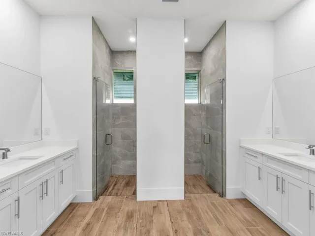Full bathroom featuring wood finished floors, a sink, and a shower stall