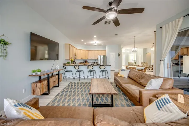 Family  room with 2 sofa, a fan and large TV