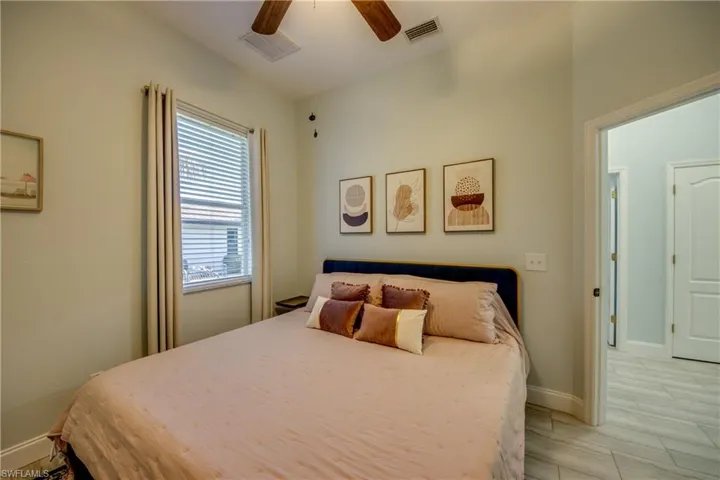 King size bed with a ceiling fan and light. Also a walk-in closet.