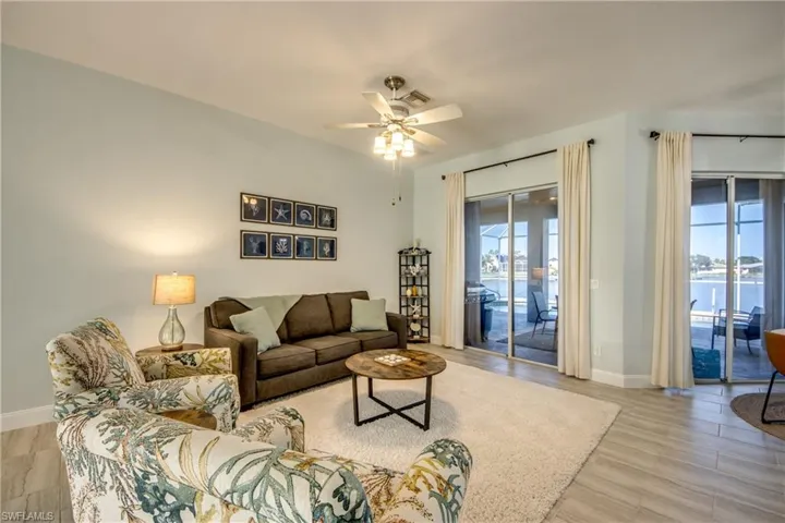 Living room with a sofa bed, ceiling fan, land a water view