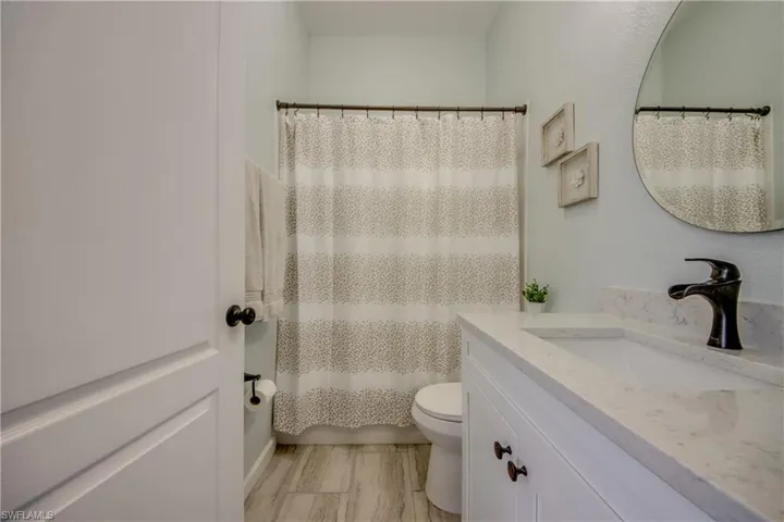 Bathroom  wiclose to the pool with vanity and shower / bathtub combination with curtain